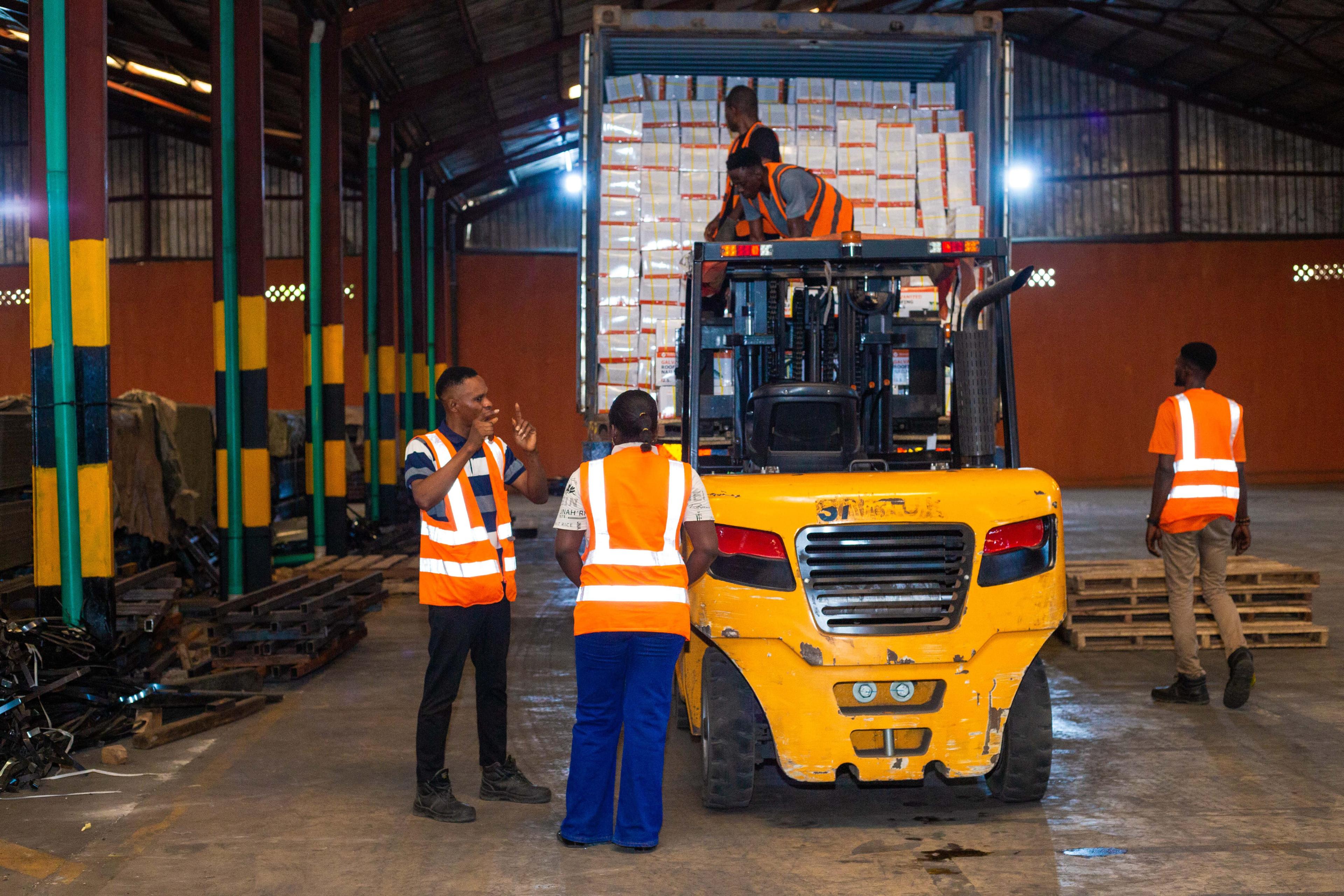 Workers with forklift in warehouse